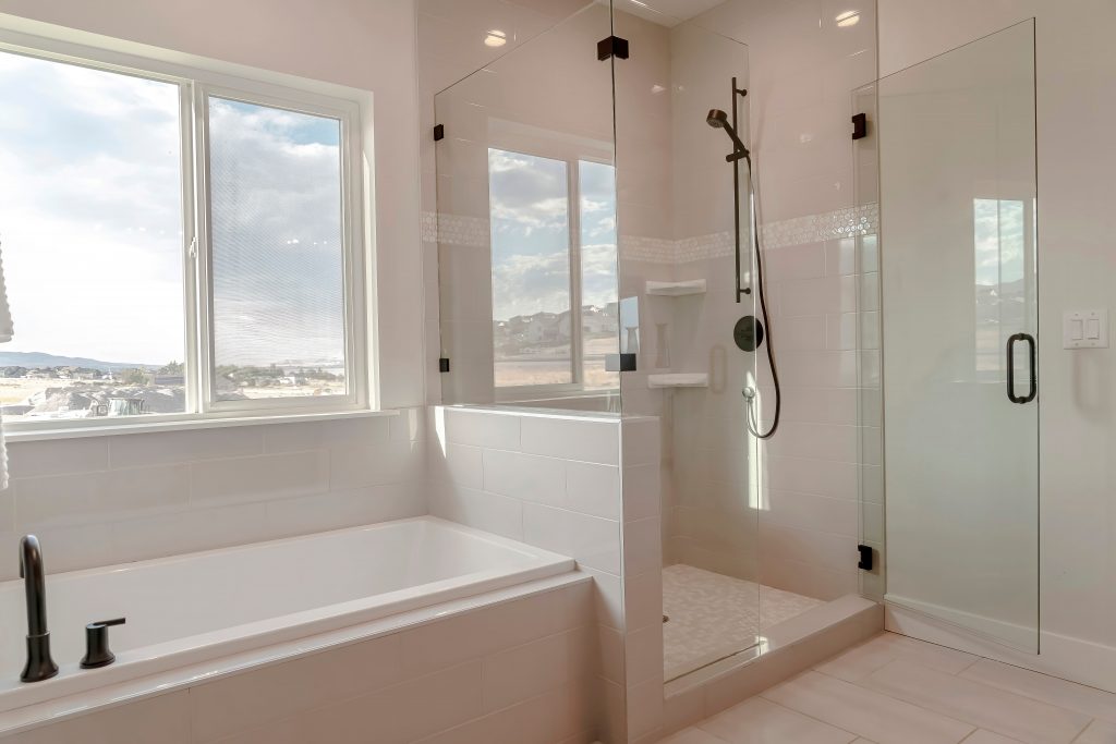 A Euro-shower Frameless European glass shower in a marble white bathroom door